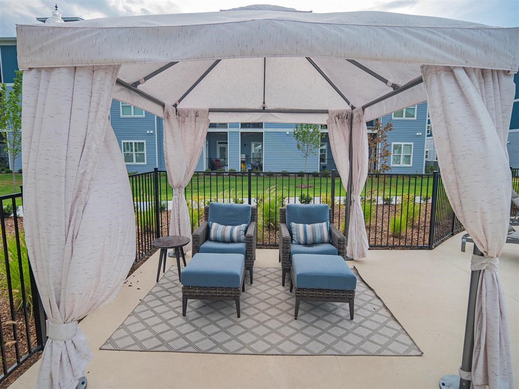 a covered patio with chairs and a gazebo