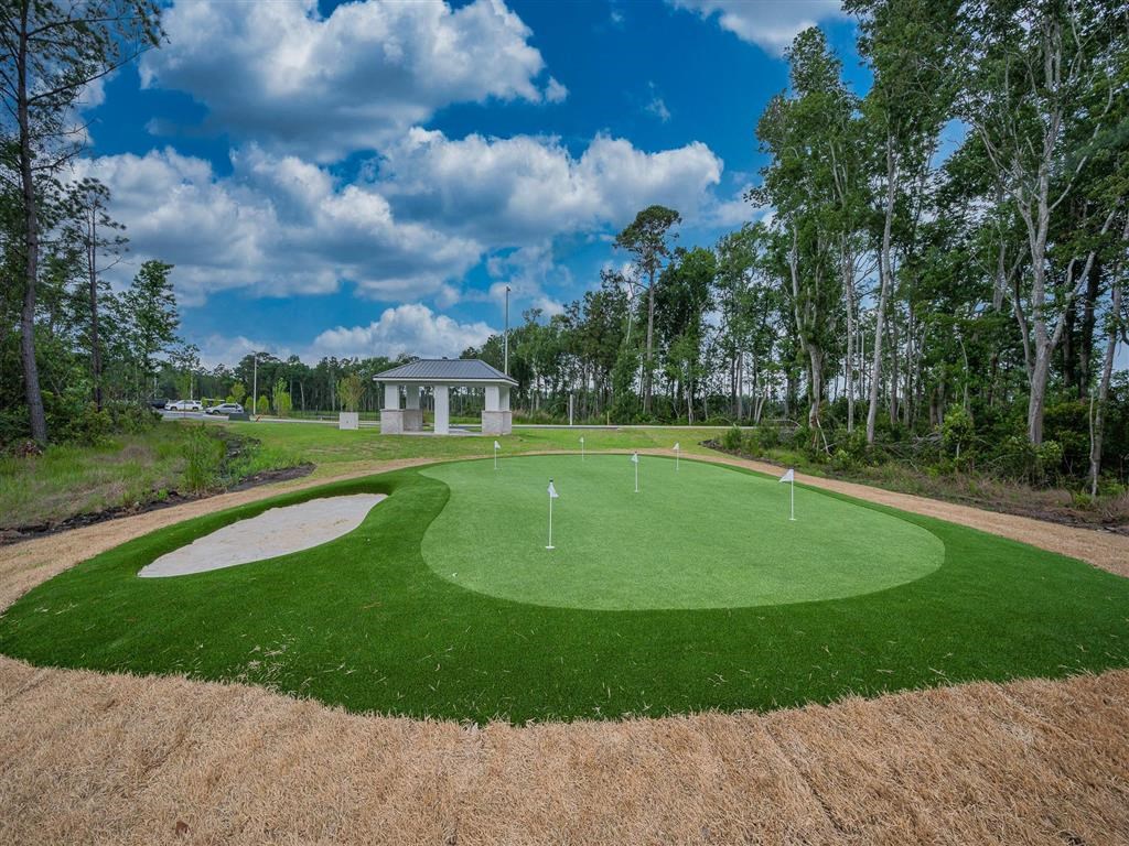 a putting green with a pavilion in the background
