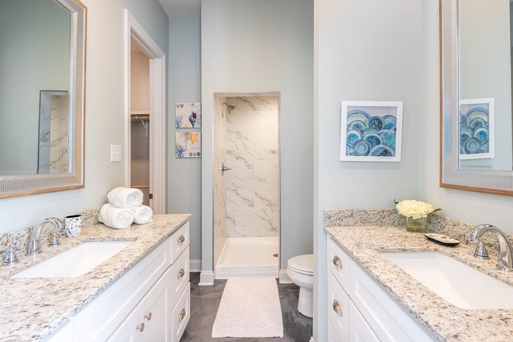 a bathroom with two sinks and a toilet and a shower