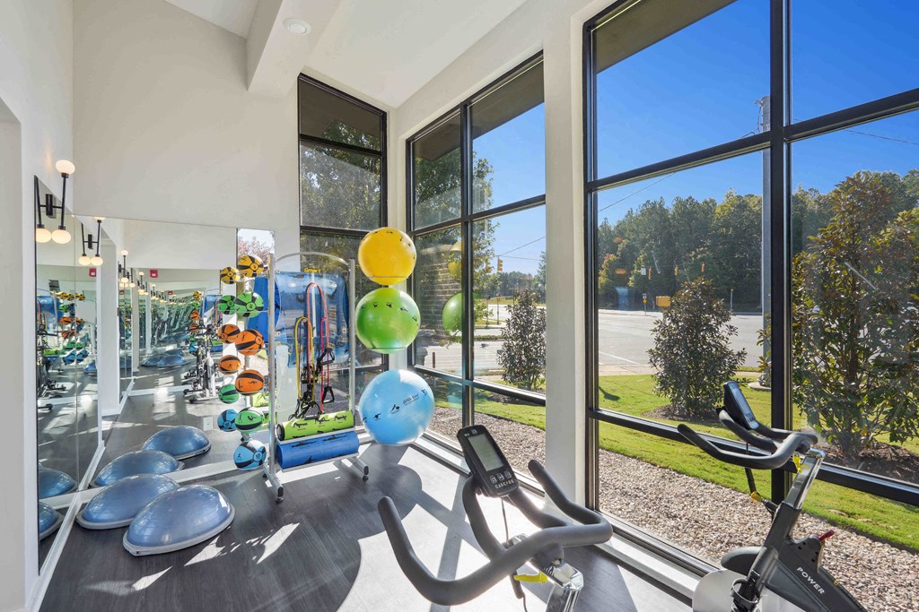a gym with exercise equipment and large windows