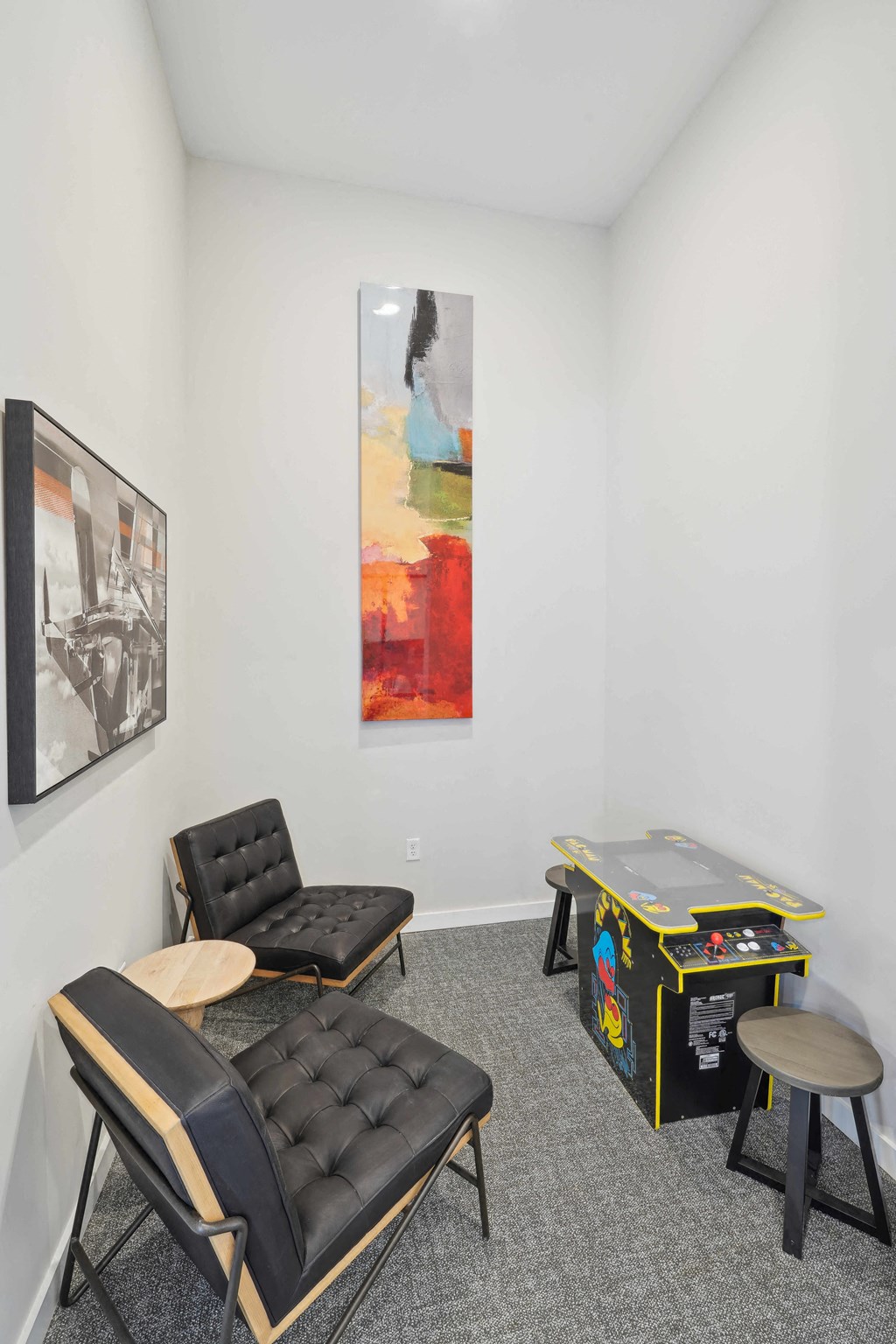 a living room with two chairs and a table with a game system