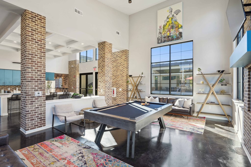 an open living room with a pool table    and a large window