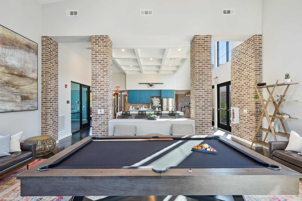 a living room filled with furniture and a pool table