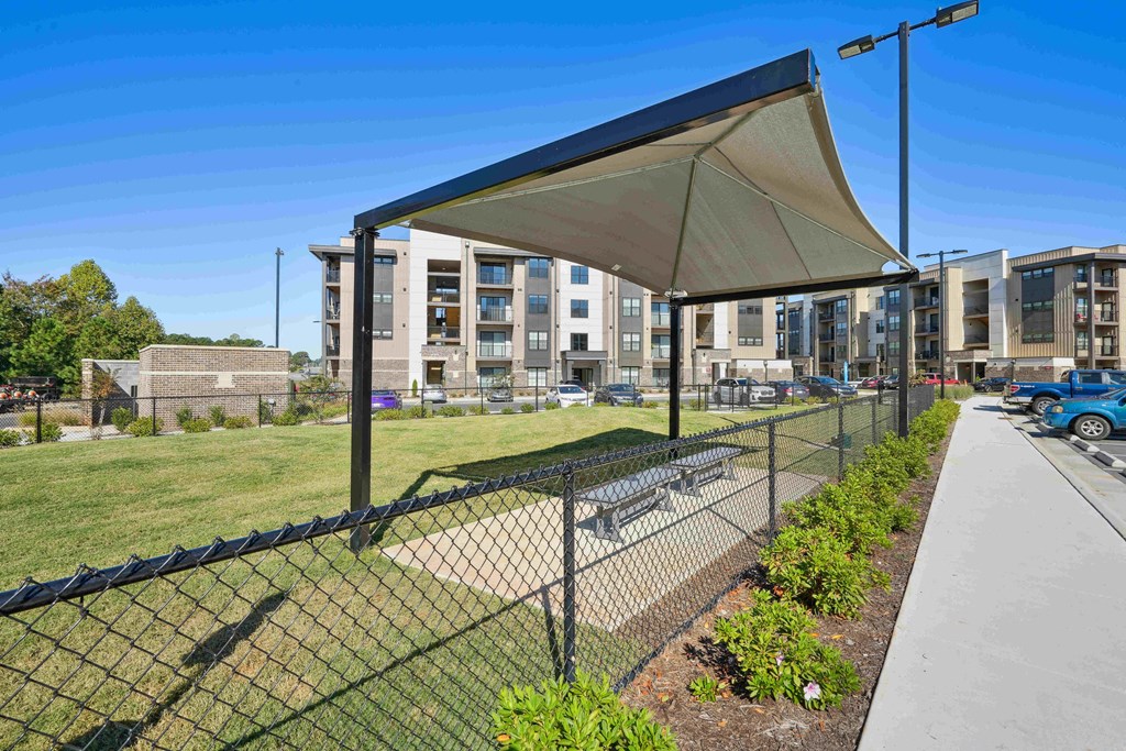 a fenced in area with a building in the background