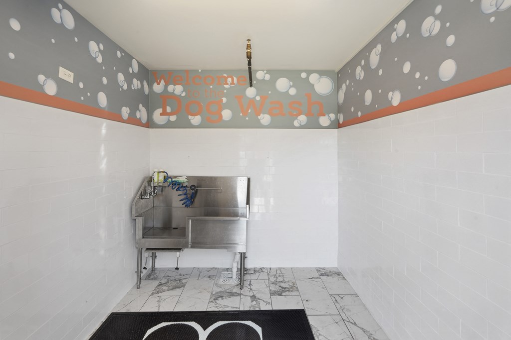 a bathroom with a sink and a tub and a sign that says cool dog wash