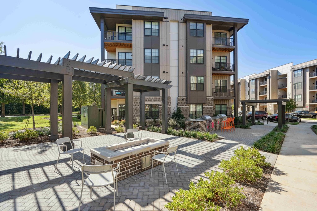 a patio with a table and chairs in front of an apartment building
