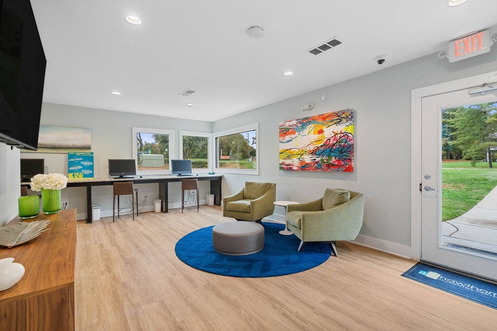 a room with a desk and two chairs and a blue rug