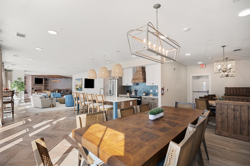 Modern clubhouse dining room with a wooden table and eight chairs surrounding.