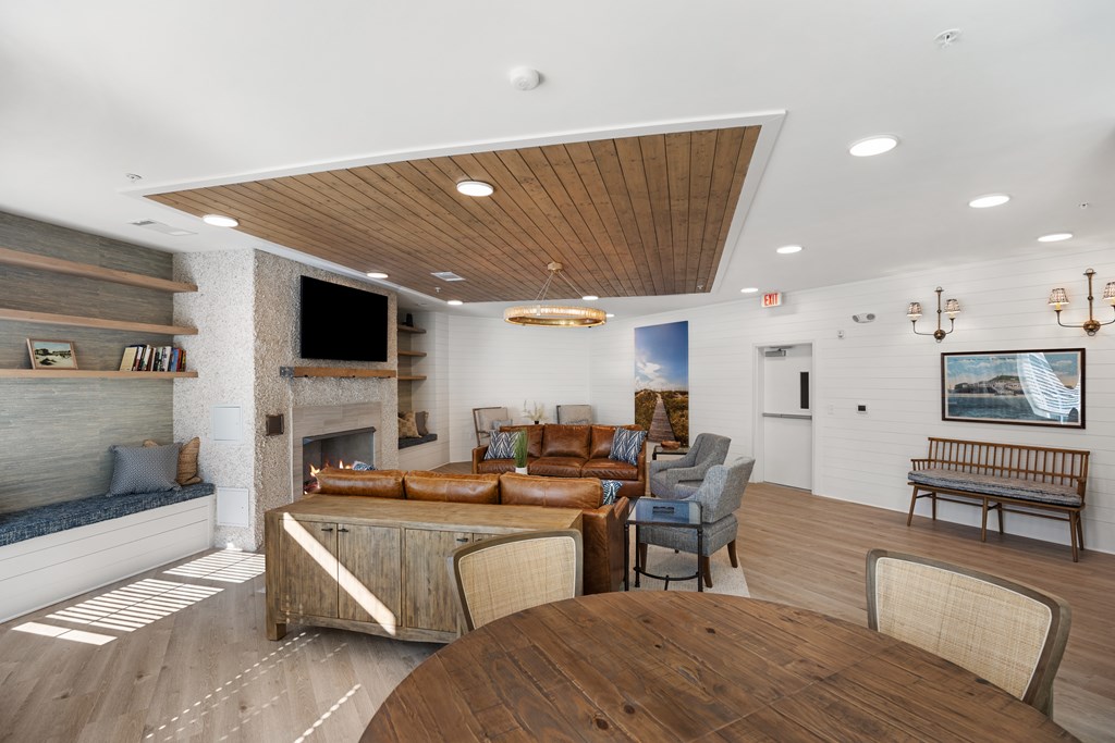 Clubhouse living room area with a fireplace and a television mounted above.
