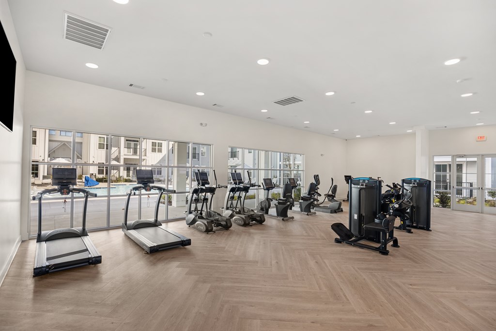 A gym with treadmills, elliptical machines, and other exercise equipment.