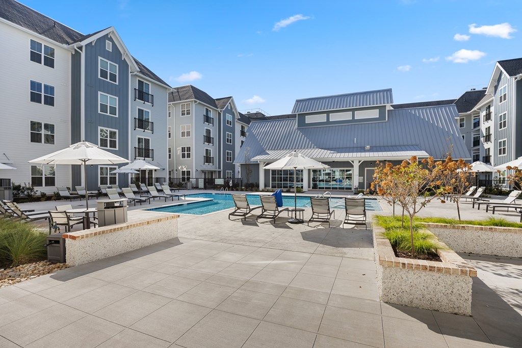 A large outdoor pool area with sun loungers and umbrellas.