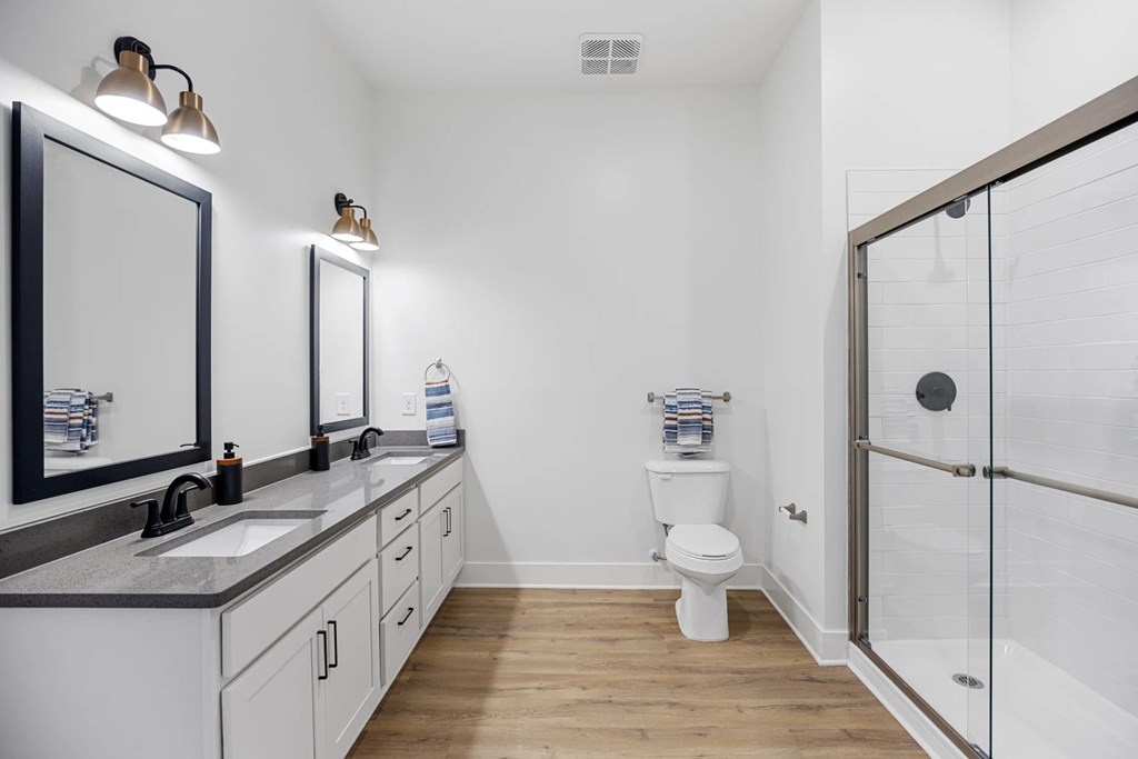 A White Bathroom with a Toilet, Sink, and Mirror.