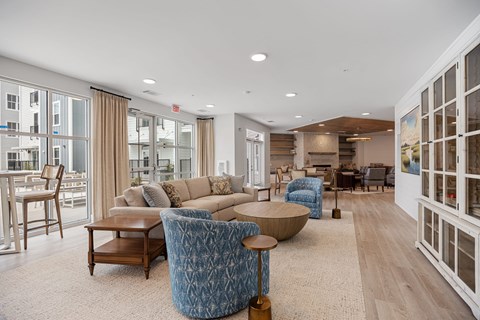 A living room with a blue chair and a tan couch.