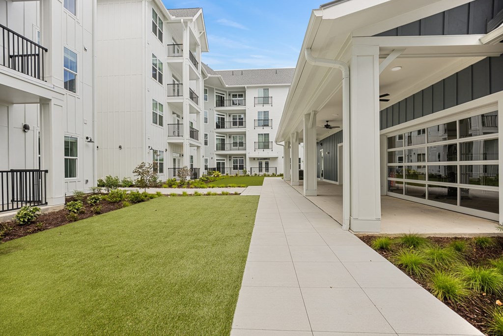 Exterior White Building with a Green Lawn in Front.