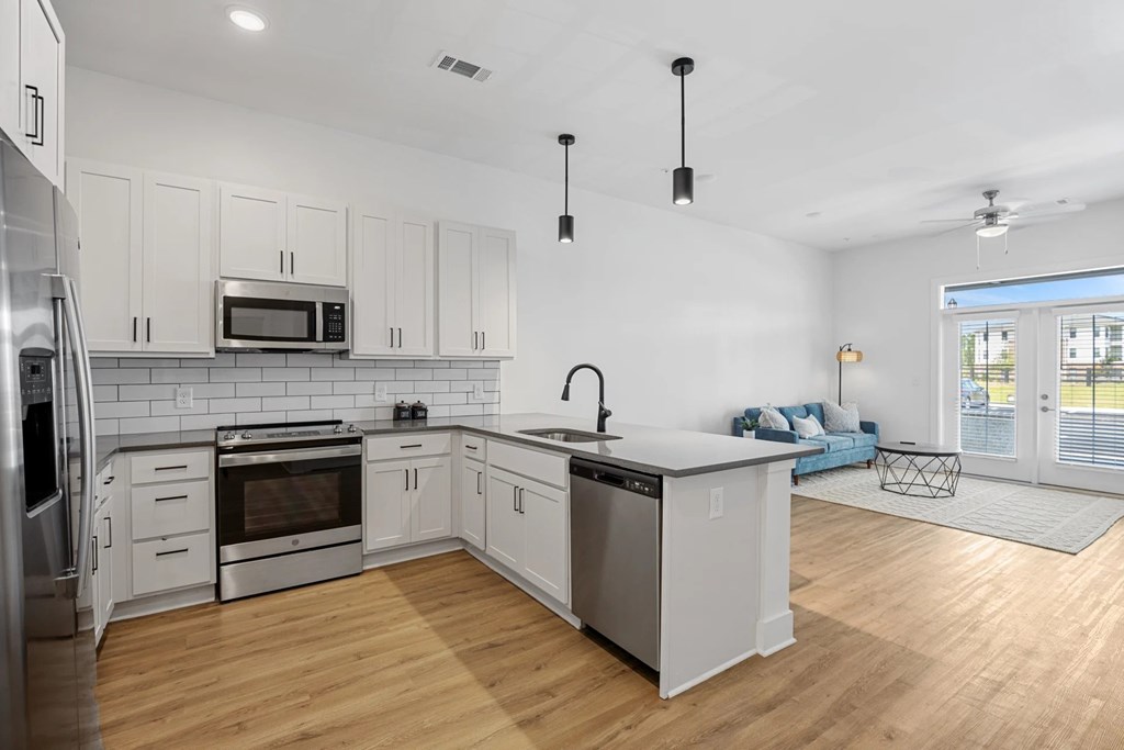 Interior Modern Kitchen with Stainless Steel Appliances and View of Living Room.