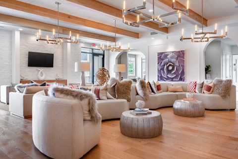 A modern living room with a white couch and a large painting on the wall.