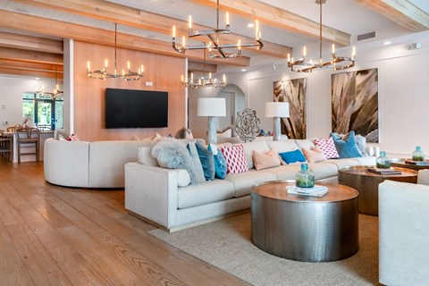 A modern living room with a white sofa and a wooden floor.
