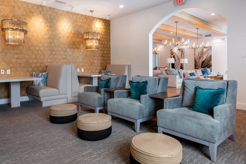 A room with grey and blue chairs and ottomans.