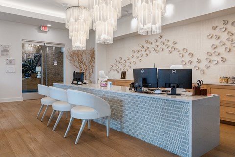 A reception area with a blue reception desk and white chairs.
