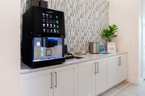 A black microwave with a digital display and control panel is placed on a kitchen counter.