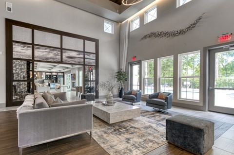 A living room with a grey couch and a large window.