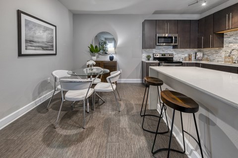 A modern kitchen with a dining table and chairs.
