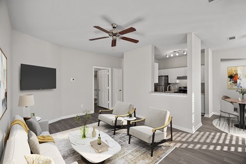 A living room with a white couch, a coffee table, and a ceiling fan at Hawthorne Bridford in Greensboro, NC