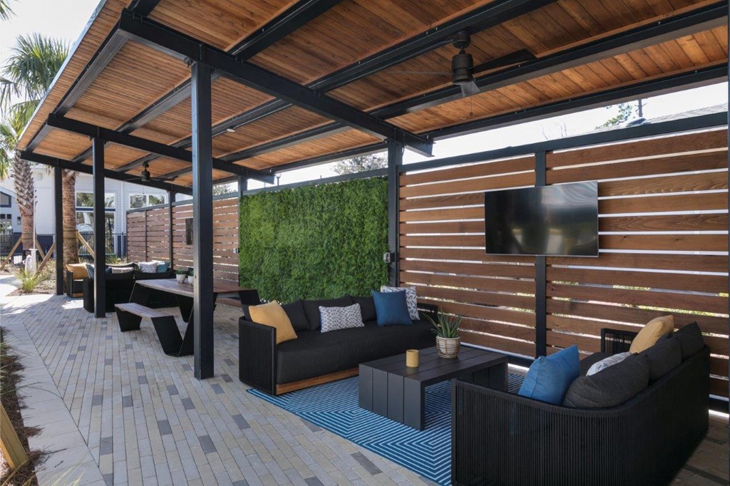 a covered patio with couches and a television