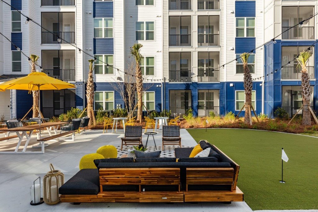 a lounge area with a couch in front of an apartment building