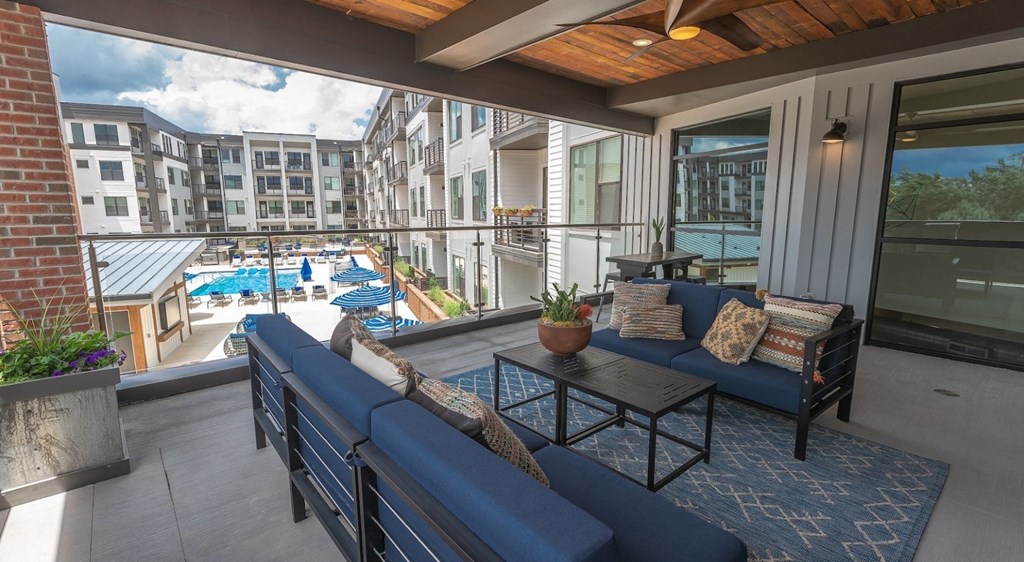 a living room with a view of a pool and a balcony
