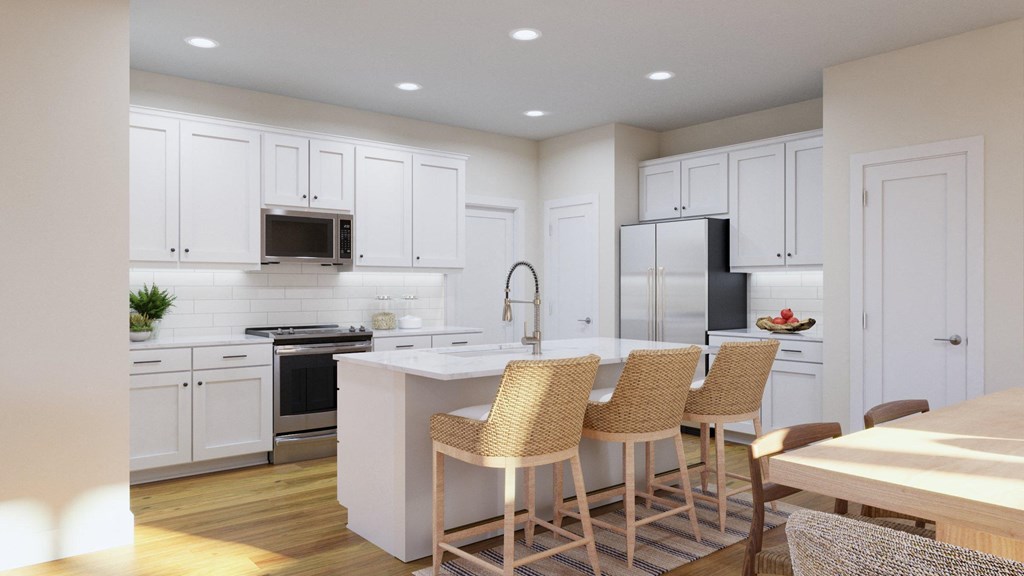 a large kitchen with white cabinets and a island with chairs