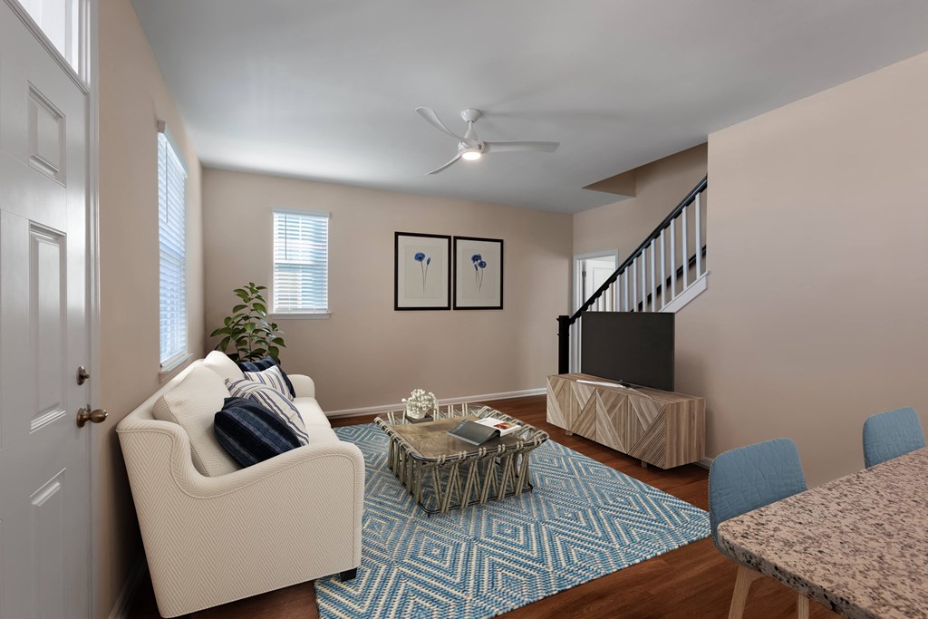 A living room with a white couch, a coffee table, and a TV.