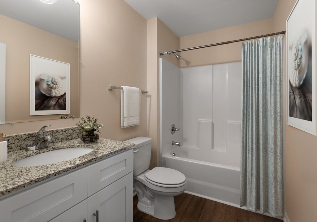 A bathroom with a toilet, sink, and shower.