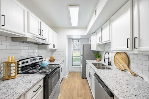 a kitchen with white cabinets and a stove and a sink