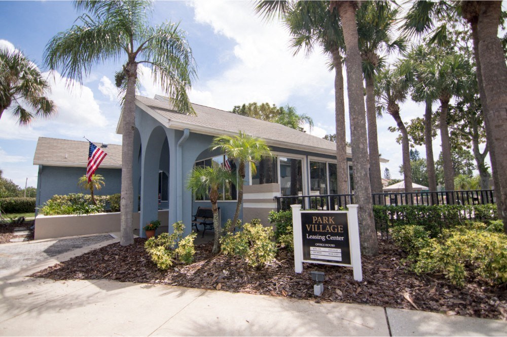 Beautiful building exterior of Park Village- blue and white buildings with palm trees