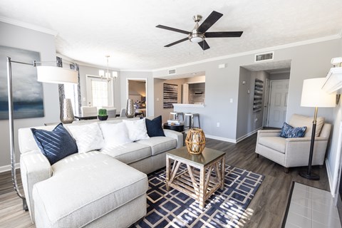 A living room with a white couch and a wooden coffee table.