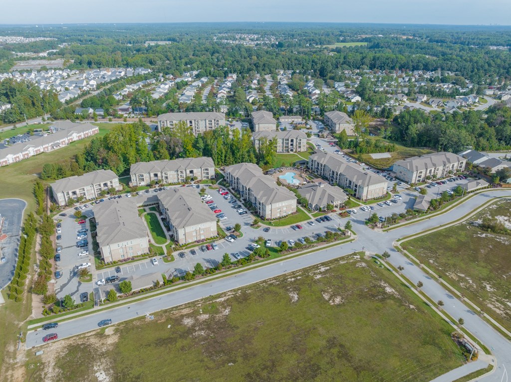 an aerial view of a neighborhood of houses and cars in a parking lot