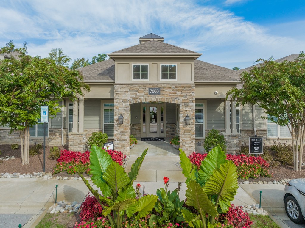 the front of a house with plants and a driveway