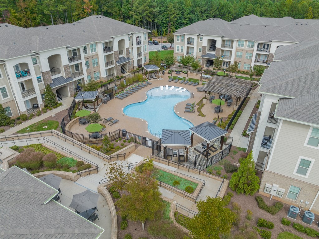 an aerial view of an outdoor pool area with apartment buildings