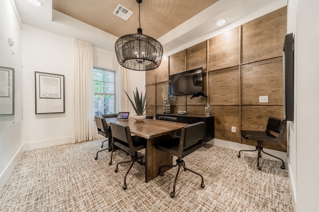 a conference room with a table and chairs and a tv