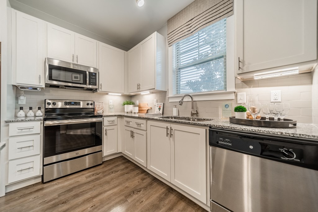 a kitchen with stainless steel appliances and white cabinets