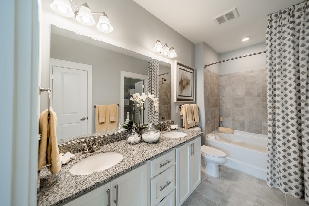 a bathroom with two sinks and a shower and a toilet