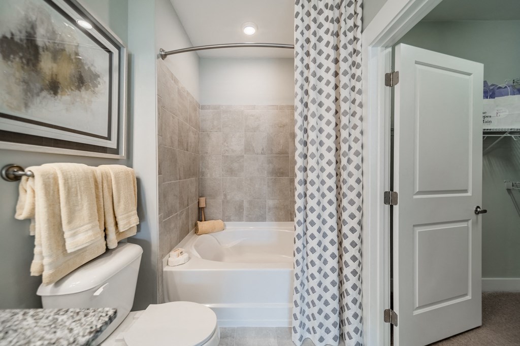 a bathroom with a tub and a toilet and a shower