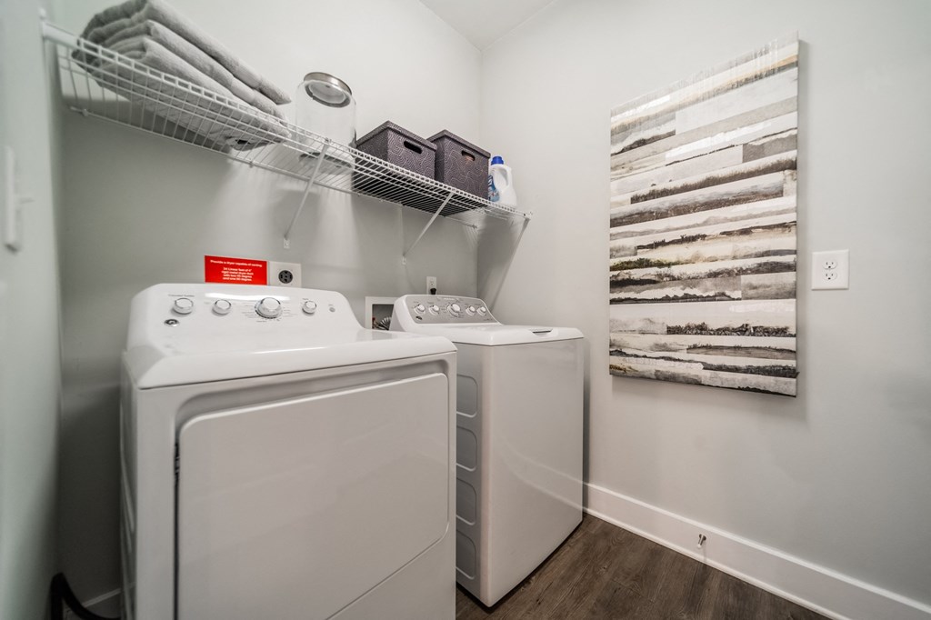 a washer and dryer in a laundry room with a shelf over the was