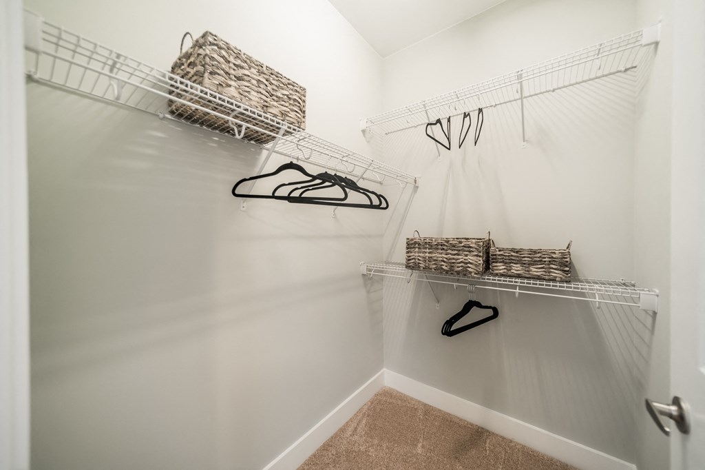 a walk in closet with a pair of shoes and baskets