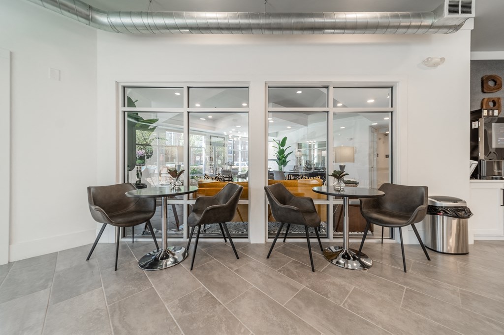 a dining area with tables and chairs and a large window