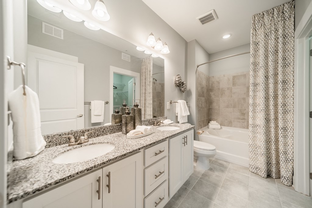 a bathroom with two sinks and a shower and a toilet