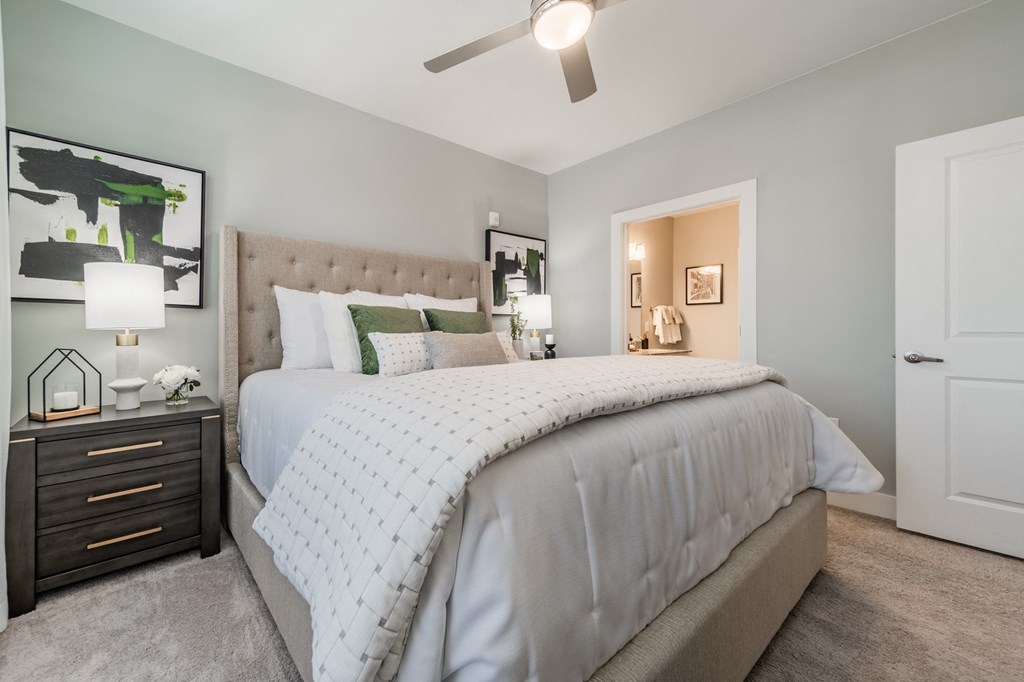 a bedroom with a large bed and a ceiling fan