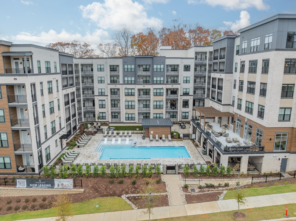 A large apartment complex with a pool in the middle.