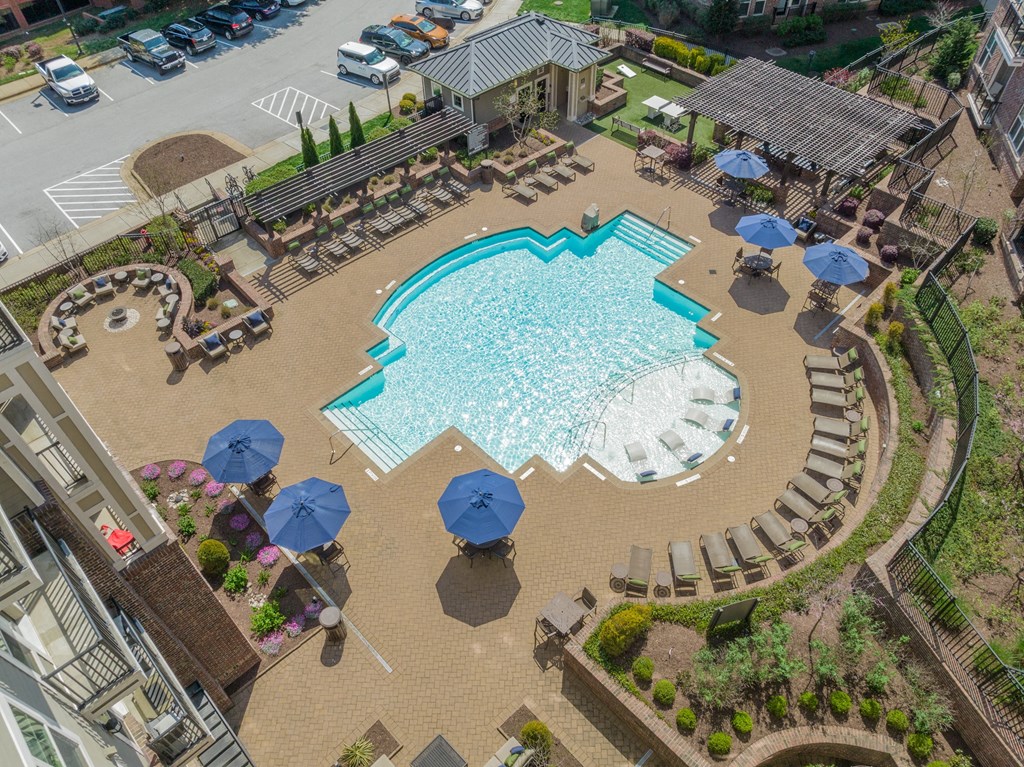 a large swimming pool with lounge chairs and umbrellas